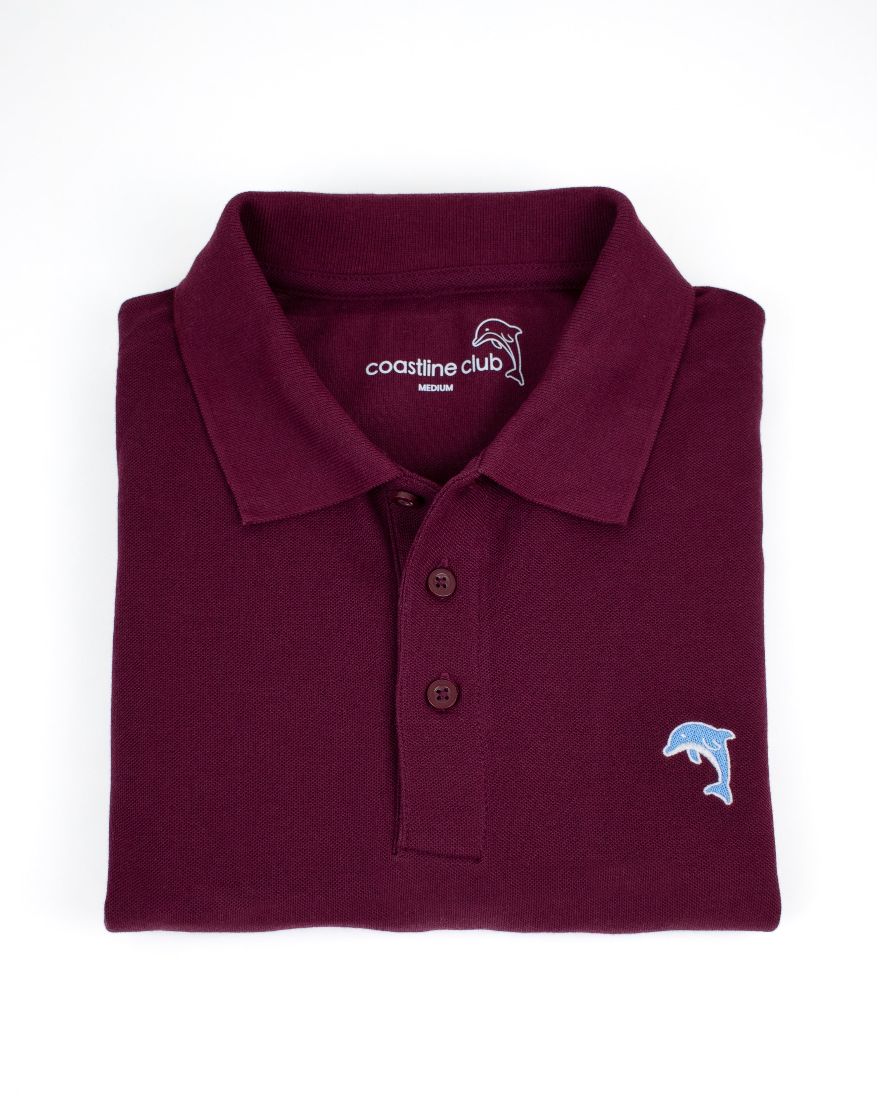 Folded maroon polo shirt with a dolphin logo on a white background
