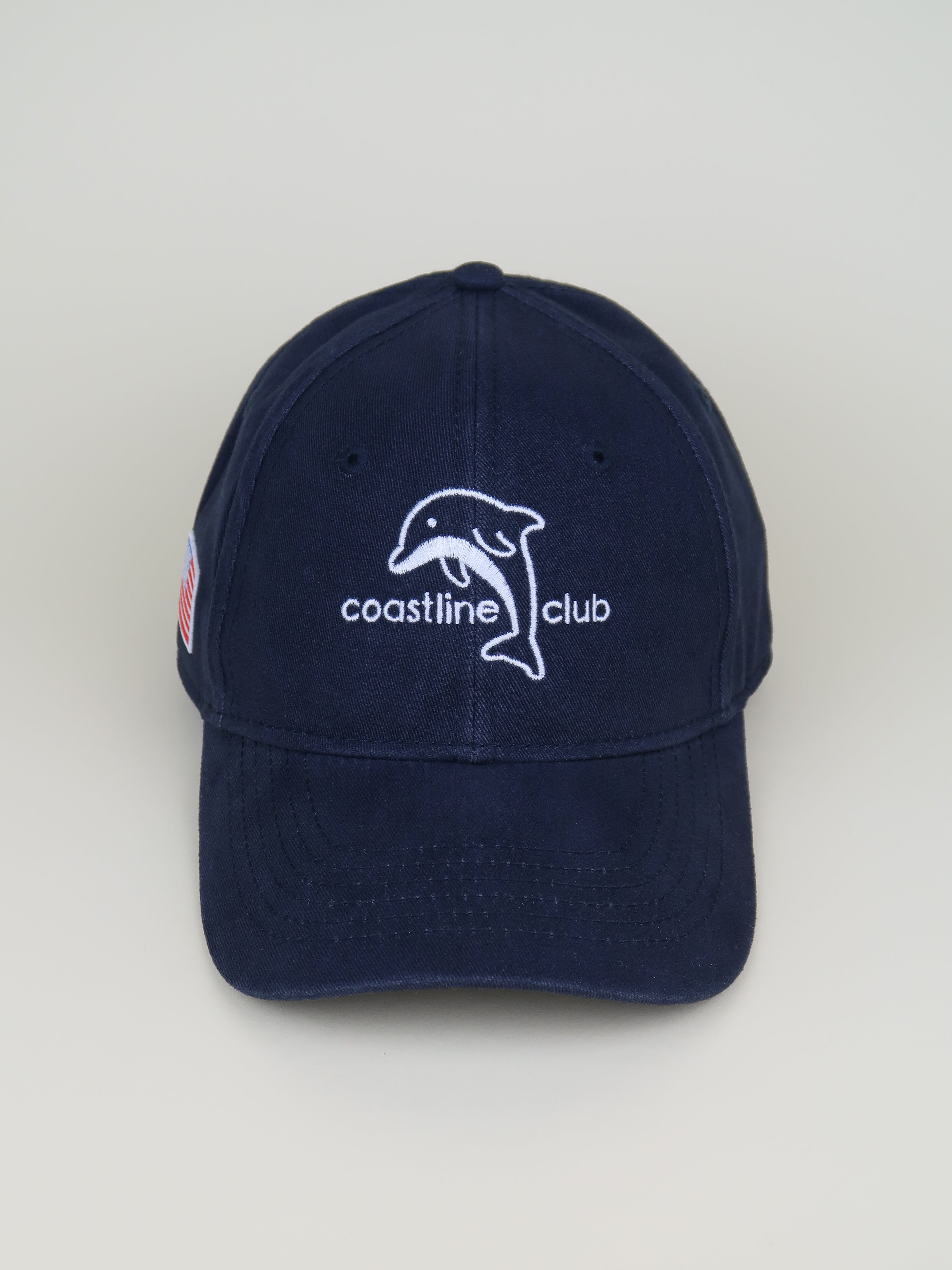 Navy blue cap with a dolphin logo and 'coastline club' text on a light gray background