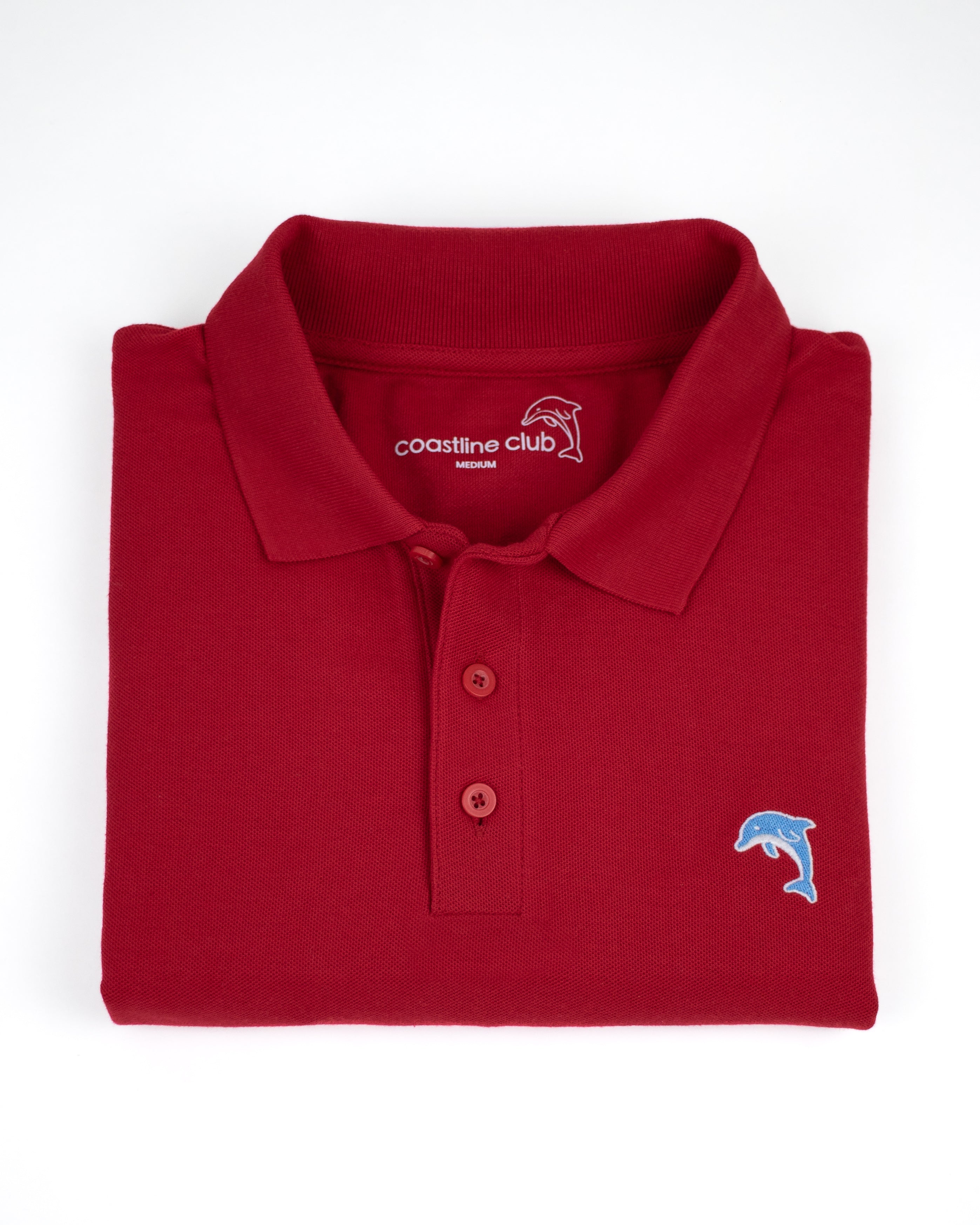Folded red polo shirt with a dolphin logo on a white background