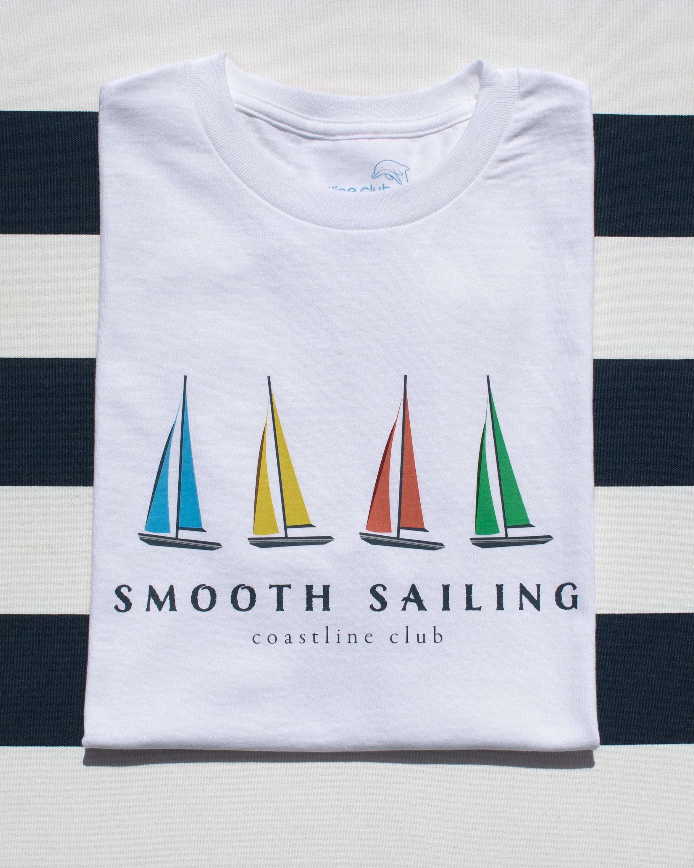 White t-shirt with sailboat design and 'Smooth Sailing' text on a striped background