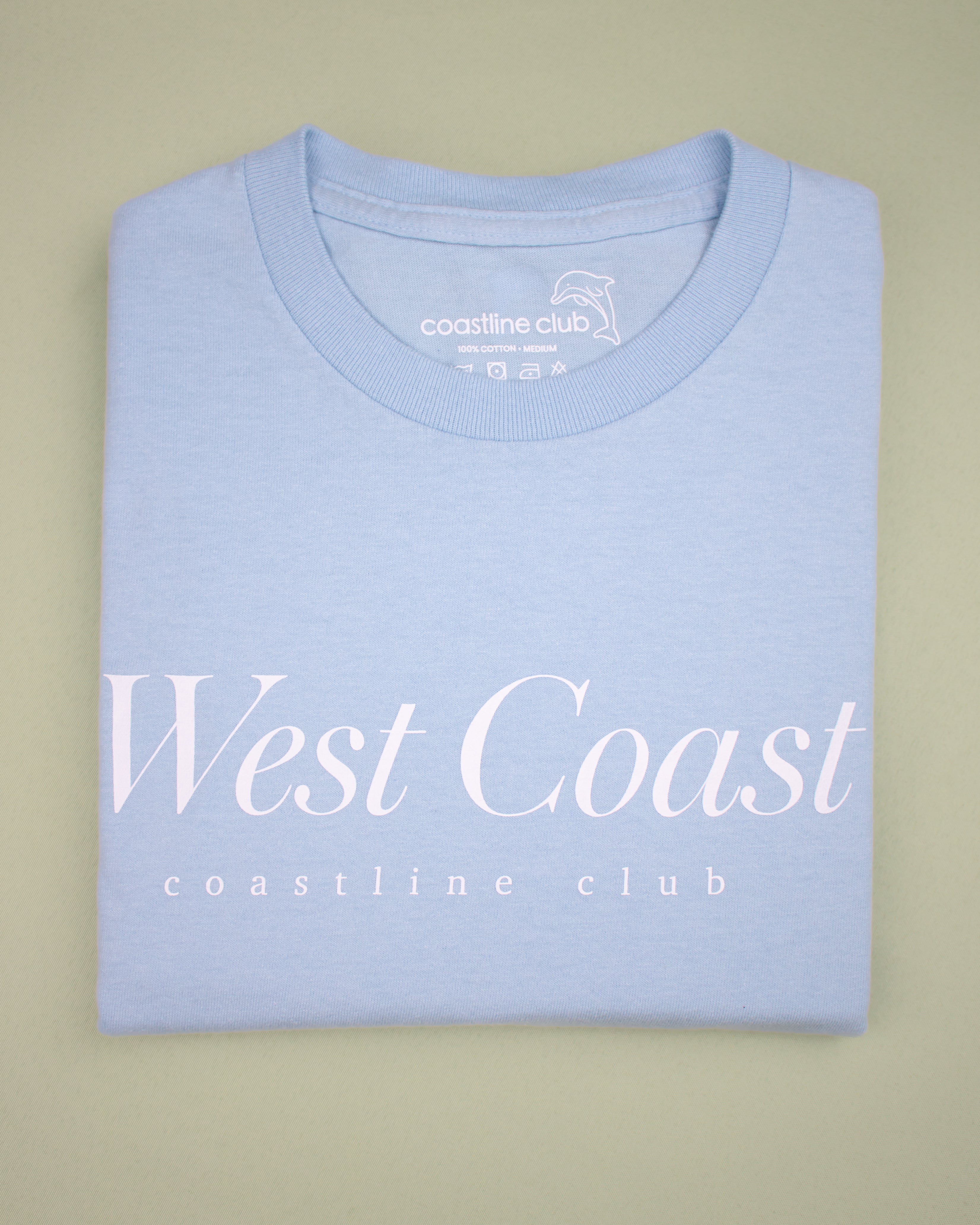 Light blue t-shirt with 'West Coast' and 'coastline club' text on a beige background