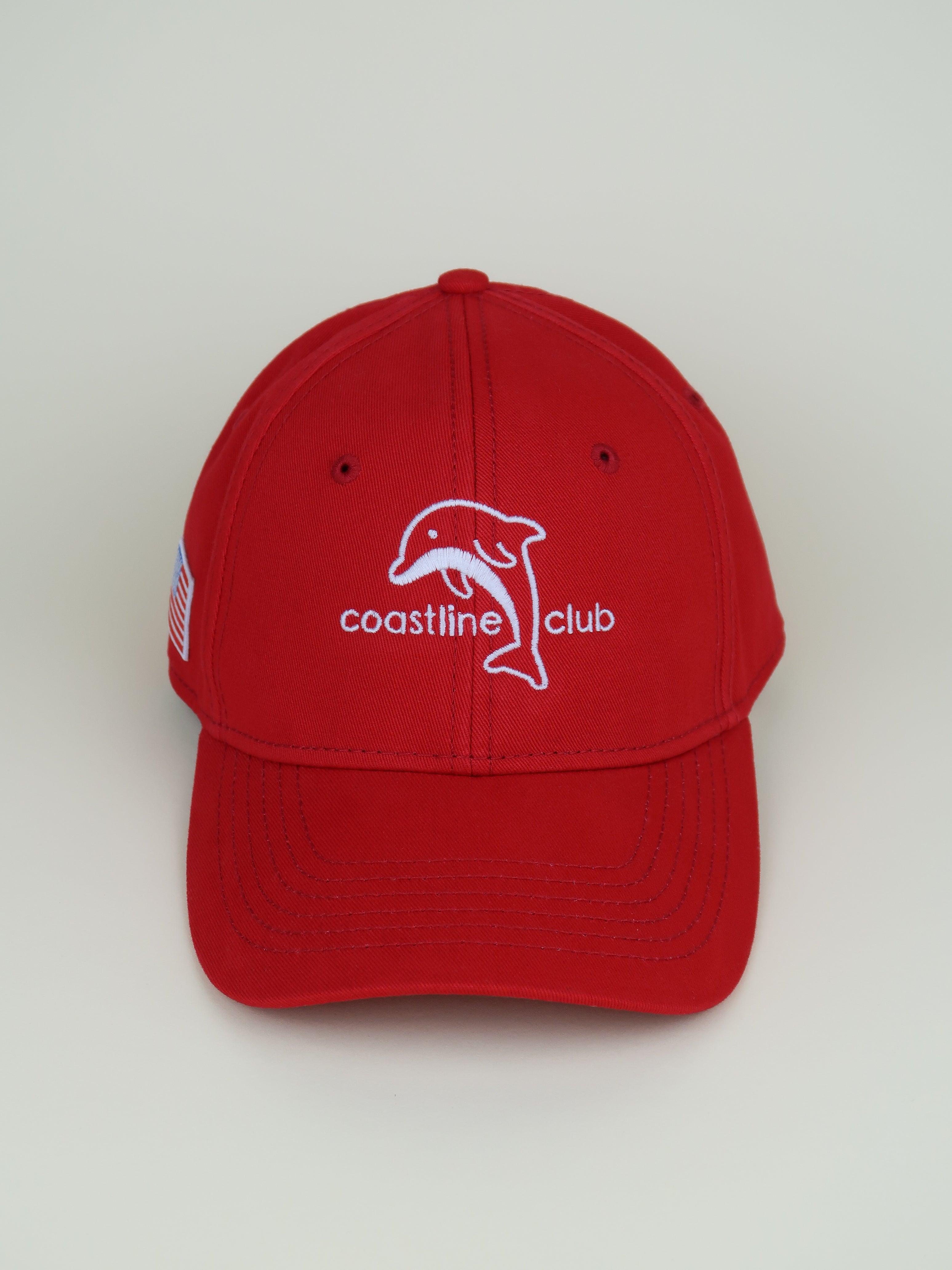 Red cap with a dolphin logo and 'coastline club' text on a white background