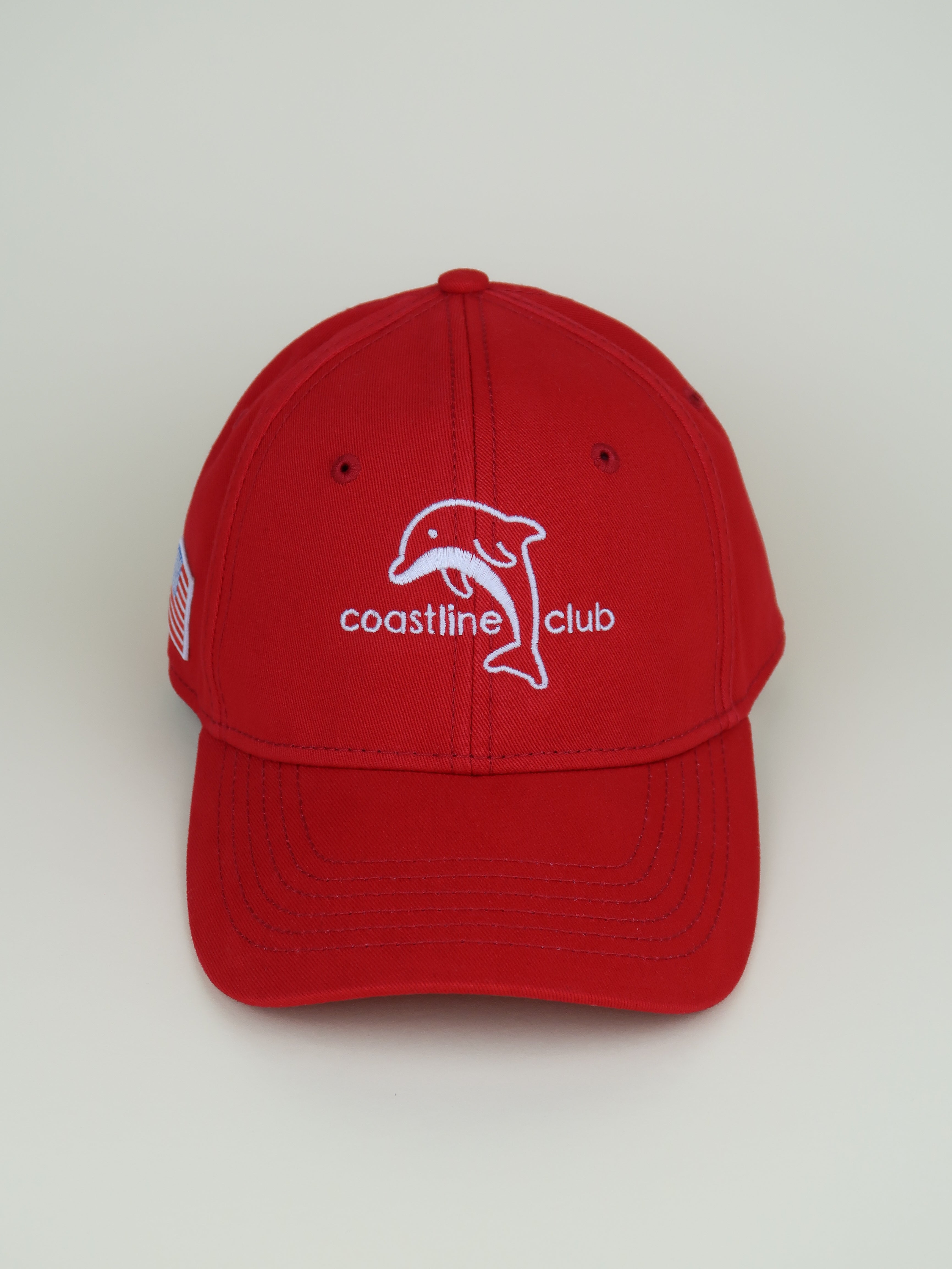 Red cap with a dolphin logo and 'coastline club' text on a white background
