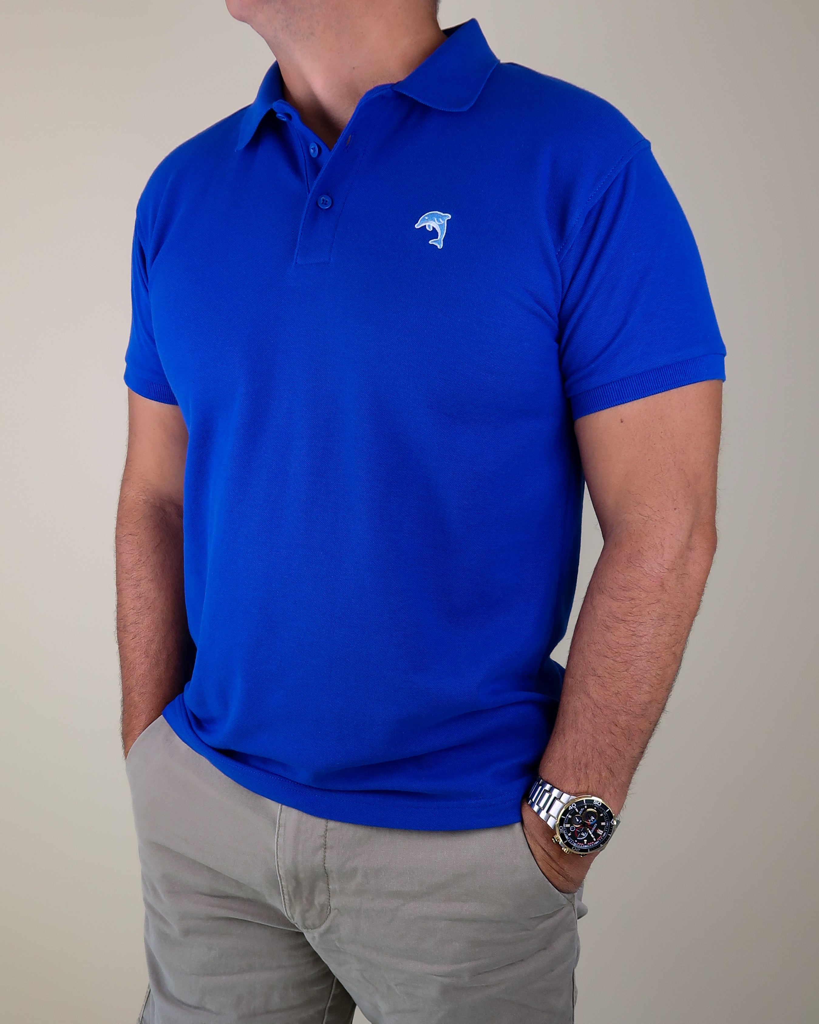 Person wearing a blue polo shirt with a dolphin logo on a plain background